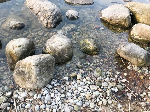 Grandi rotondi belle pietre naturali ciottoli in acqua mare lago fiume Trama di sfondo