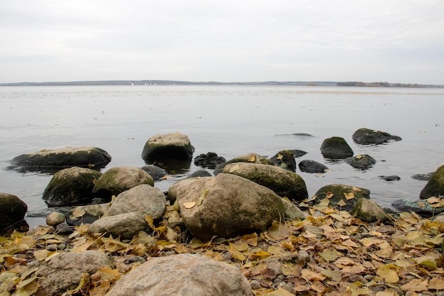 Grandi sassi sulla riva del lago in autunno