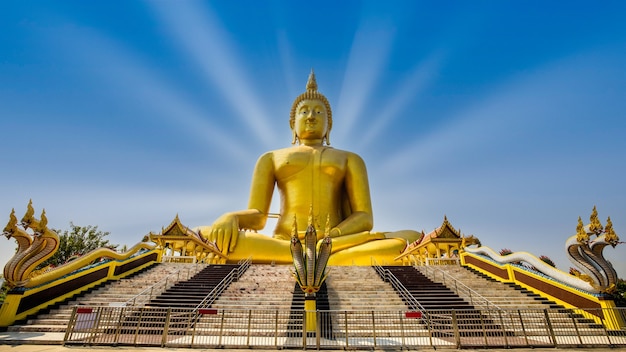 Grandi statue dorate di Buddha con serpente davanti in ang thong Thailandia