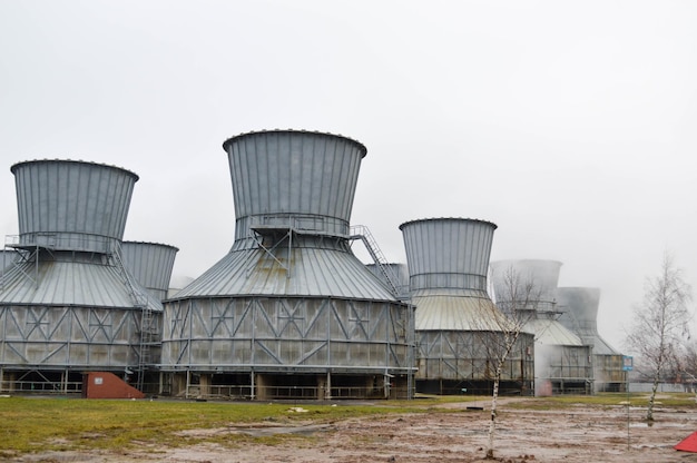 Grandi torri di raffreddamento in acqua e nebbia in un impianto chimico petrolchimico di una raffineria di petrolio