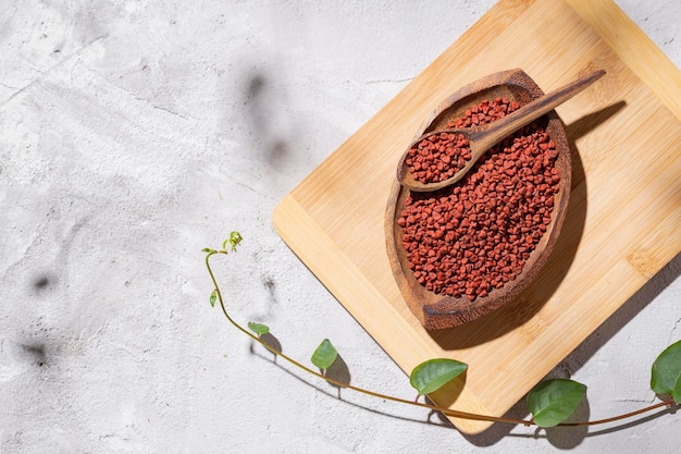 Grani Achiote in ciotola di legno su sfondo bianco Bixa orellana