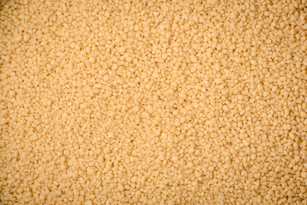 Grani di couscous di porridge di grano su uno sfondo di cemento scuro