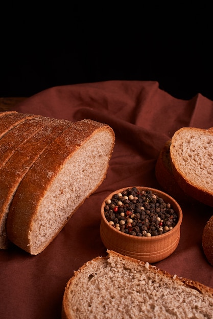 Grani di pepe in una ciotola di legno sul tavolo con stile rustico di cibo