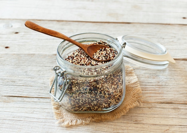 Grani di quinoa misti crudi in un bicchiere da vicino