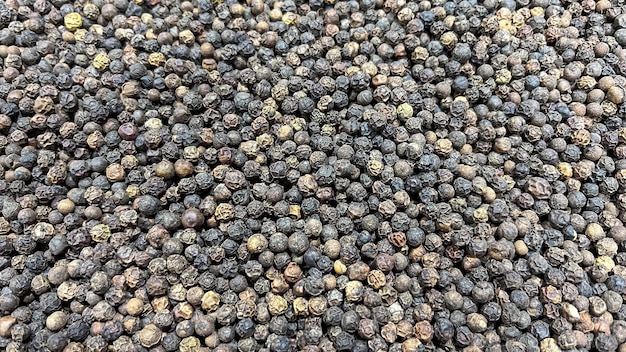 Grani interi di pepe nero su una bancarella di un bazar di spezie in una strada di Aswan, in Egitto