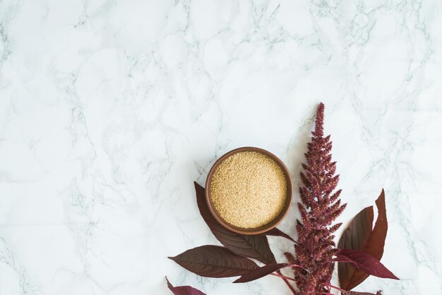 grano di amaranto con olio su sfondo bianco con spazio per il testo