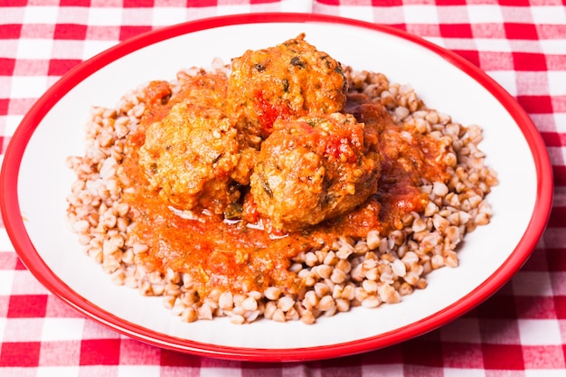 Grano saraceno bollito con polpette al sugo di pomodoro sul piatto