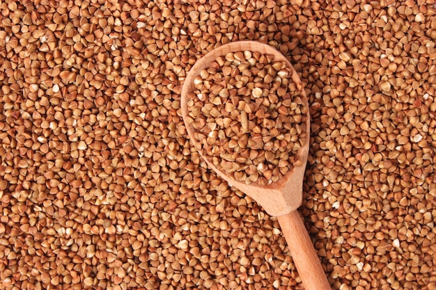 Grano saraceno crudo su un primo piano colorato del fondo