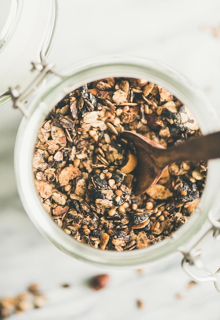 Grano saraceno e granola con nocciole in vasetto di vetro con cucchiaio