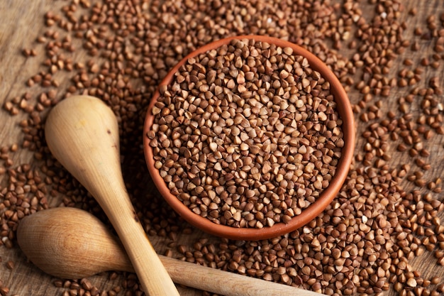 Grano saraceno in ciotola sul tavolo e cucchiai