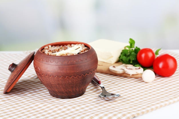 Grano saraceno in pentola con il primo piano di burro e verdure