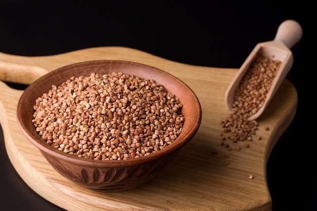 Grano saraceno in una ciotola di argilla su una tavola di legno