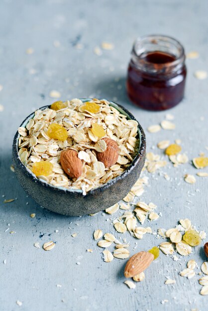 Granola a casa in una ciotola e marmellata in una bottiglia