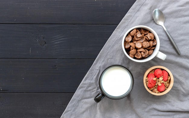 Granola casalingo con latte per la prima colazione sulla tavola di legno.