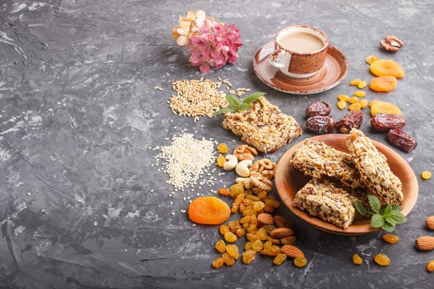 Granola fatta in casa con fiocchi d'avena, datteri, albicocche secche, uvetta, noci con una tazza di caffè. Vista laterale