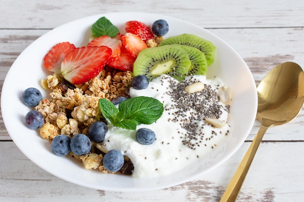 Granola fatta in casa con yogurt, frutti di bosco freschi e frutta Concetto di alimentazione sana