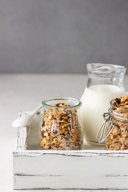 Granola in barattoli di vetro con uvetta e latte. Colazione salutare.