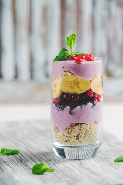 Granola in un bicchiere con yogurt e frutti di bosco