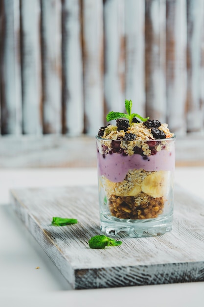 Granola in un bicchiere con yogurt e frutti di bosco