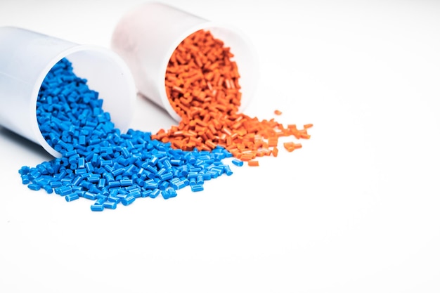 Granuli di plastica da vicino per contenere, granuli di plastica colorati con sfondo bianco.