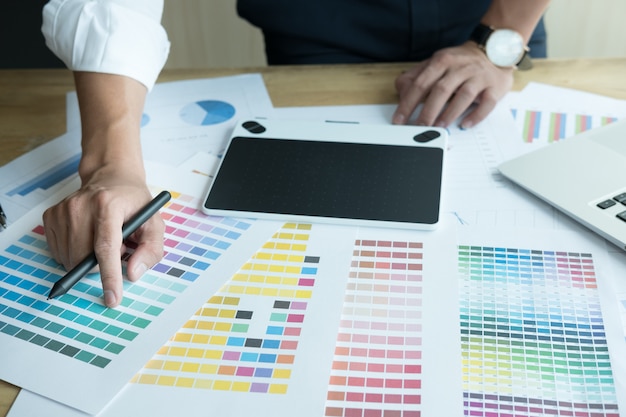 graphic designer che lavora con computer e campioni di colore