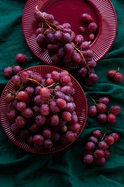 Grappoli d'uva succosa di ciliegia dolce giacciono su piatti di ciliegio che stanno su una tovaglia verde