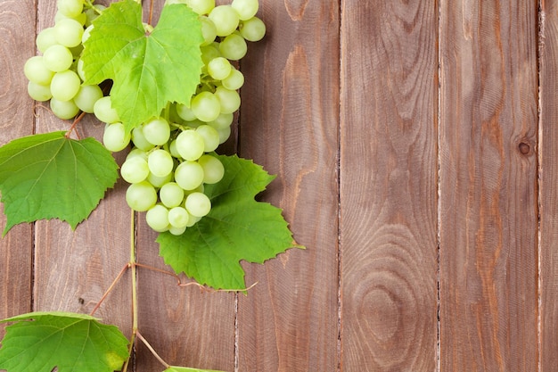 Grappolo d'uva e vite sulla tavola di legno