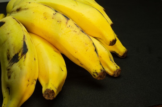 grappolo di banana gialla sotto lo sfondo nero