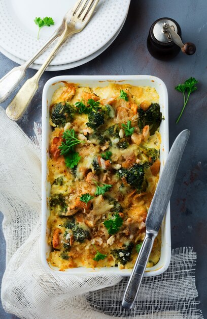 Graten di broccoli, pollo e spezie con salsa di formaggio in forma di ceramica bianca