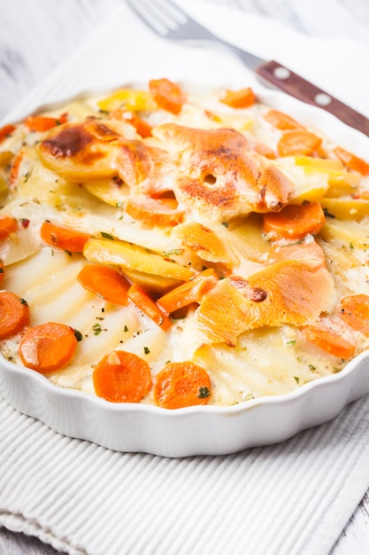 Gratin di patate e carote alle erbe in ciotola