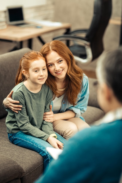 Grato per l'aiuto. Felicissima madre e figlia che guardano il loro dottore mentre sono grate per l'aiuto