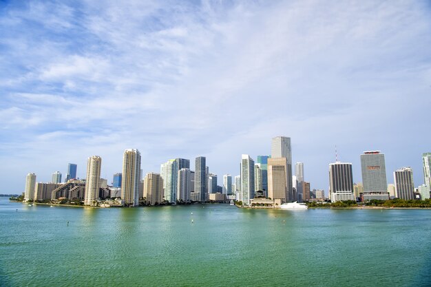Grattacieli di Miami con cielo nuvoloso blu, barca bianca vicino al centro di Miami, vista aerea