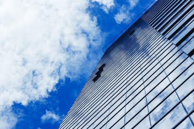 Grattacielo di vetro edificio con sfondo nuvoloso cielo blu
