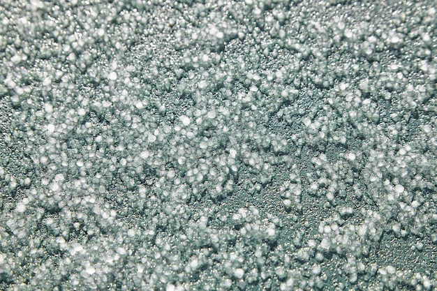 Graupel, palline di neve o morbida grandine, sfondo azzurro. Forma di precipitazione, macro, vista dall'alto