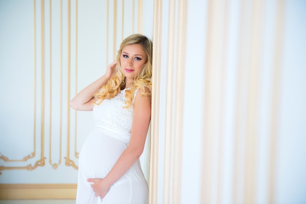 Gravidanza in un abito di pizzo bianco. Aspettando il bambino.