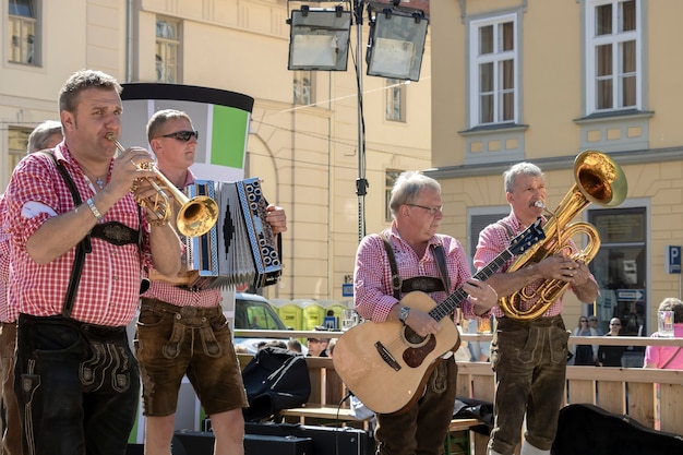 Graz / Austria - settembre 2019: festival autunnale annuale della cultura popolare della Stiria (Aufsteirern). Gruppo di uomini in abiti tradizionali luminosi che suonano musica popolare in una piazza cittadina.