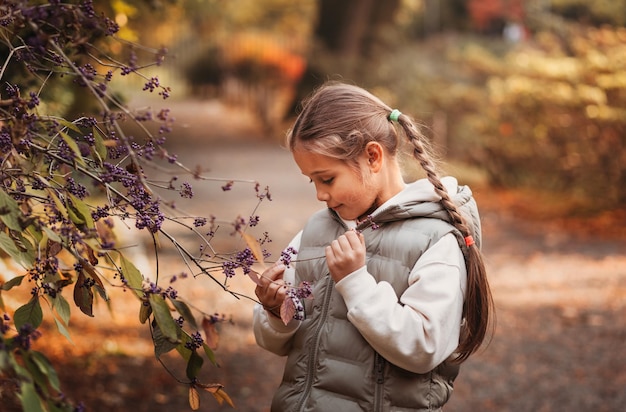 graziosa bambina che riposa nel parco autunnale