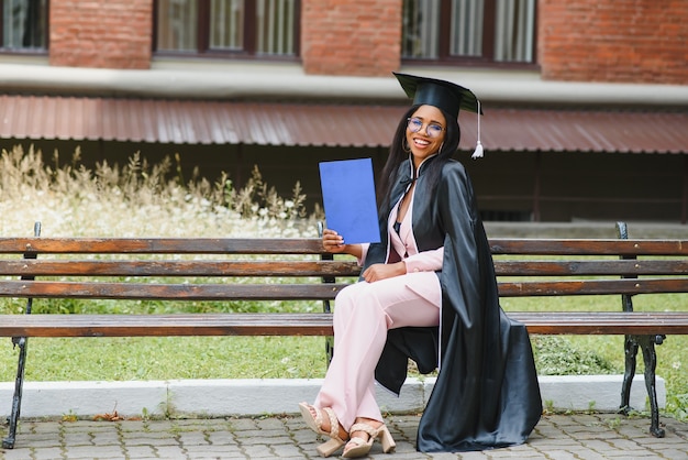 Graziosa donna afroamericana laureata fuori dall'edificio del college