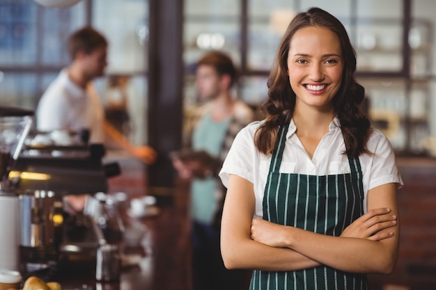 Grazioso barista con le braccia incrociate