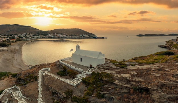 Grecia Isola di Kea Tzia Piccola chiesa bianca su una collina rocciosa sopra il porto di Korissia al tramonto