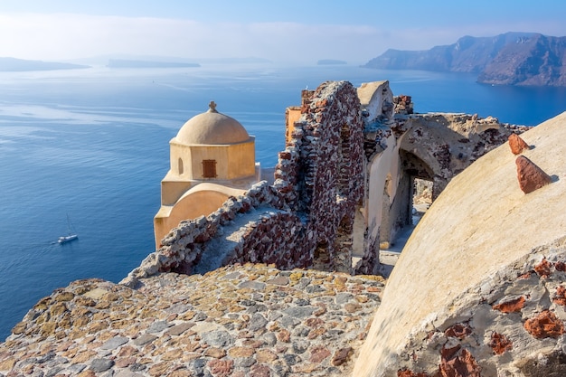 Grecia. Isola di Santorini (Thira) con tempo soleggiato. Chiesa e vecchie rovine sulla caldera di Oia. Vista panoramica sul mare