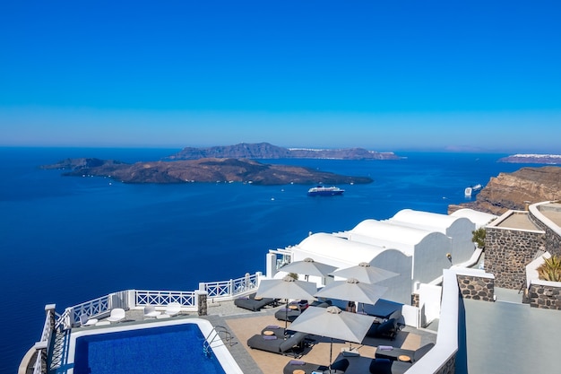 Grecia. Santorini. Isola di Thira. Hotel sulla sponda alta di Oia. Piscina e lettini per rilassarsi con tempo soleggiato. Paesaggio marino