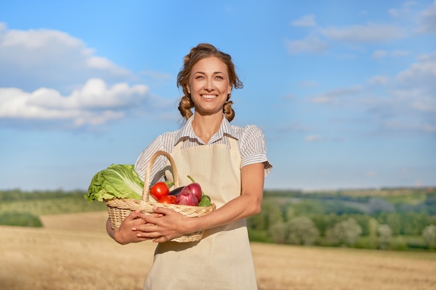 Grembiule agricoltore donna in piedi terreni agricoli sorridente Agronomo femmina specialista agricoltura agroalimentare Felice lavoratore indoeuropeo positivo campo agricolo