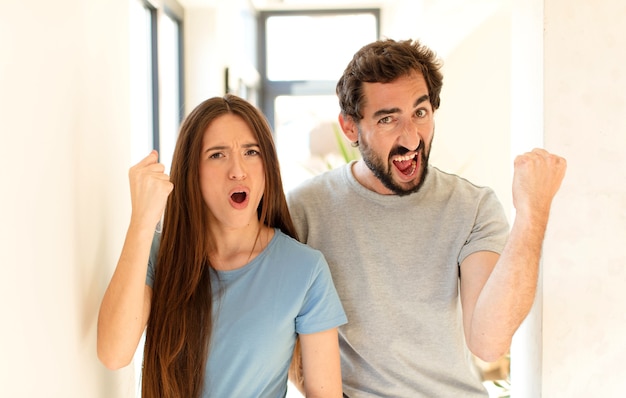 gridando in modo aggressivo con un'espressione arrabbiata o con i pugni chiusi celebrando il successo