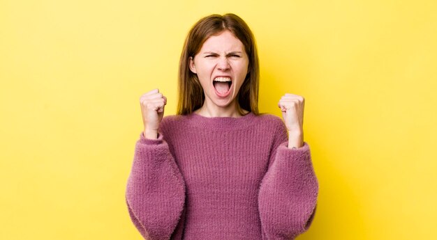 gridando in modo aggressivo con un'espressione arrabbiata o con i pugni serrati per celebrare il successo