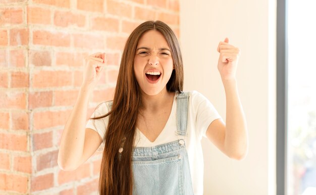 gridare in modo aggressivo con un'espressione arrabbiata o con i pugni chiusi celebrando il successo