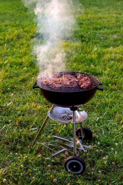 Griglia per barbecue con fumo sulla natura all'aperto Composizione satura del barbecue tempo di cottura alla griglia