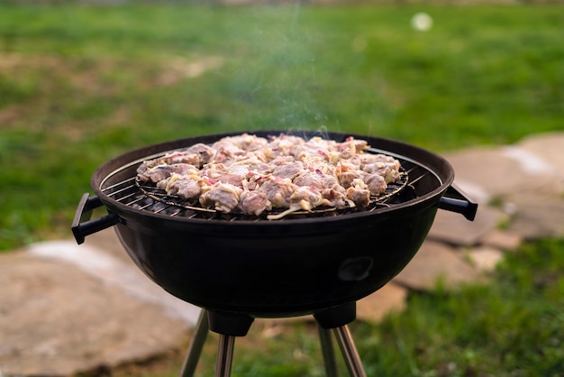 Grigliare carne alla griglia all'aperto nel cortile sul retro.