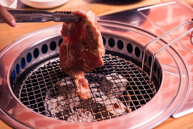 Grigliare carne di maiale in stile tradizionale barbecue coreano sul fornello servire nel ristorante