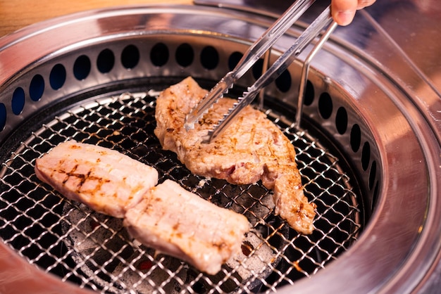 Grigliare carne di maiale in stile tradizionale barbecue coreano sul fornello servire nel ristorante